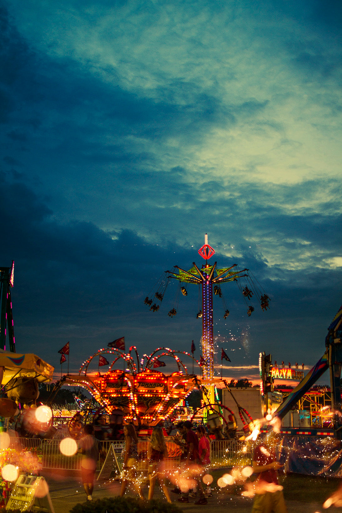 This photograph by Shannon Black presents a captivating interplay between the static and the ephemeral, the grounded reality of the fair and the transient beauty of the light sparks. It invites viewers to reflect on the fleeting nature of enjoyment and the preciousness of moments that illuminate our lives.
